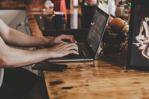 ノートパソコンでライティングする男性